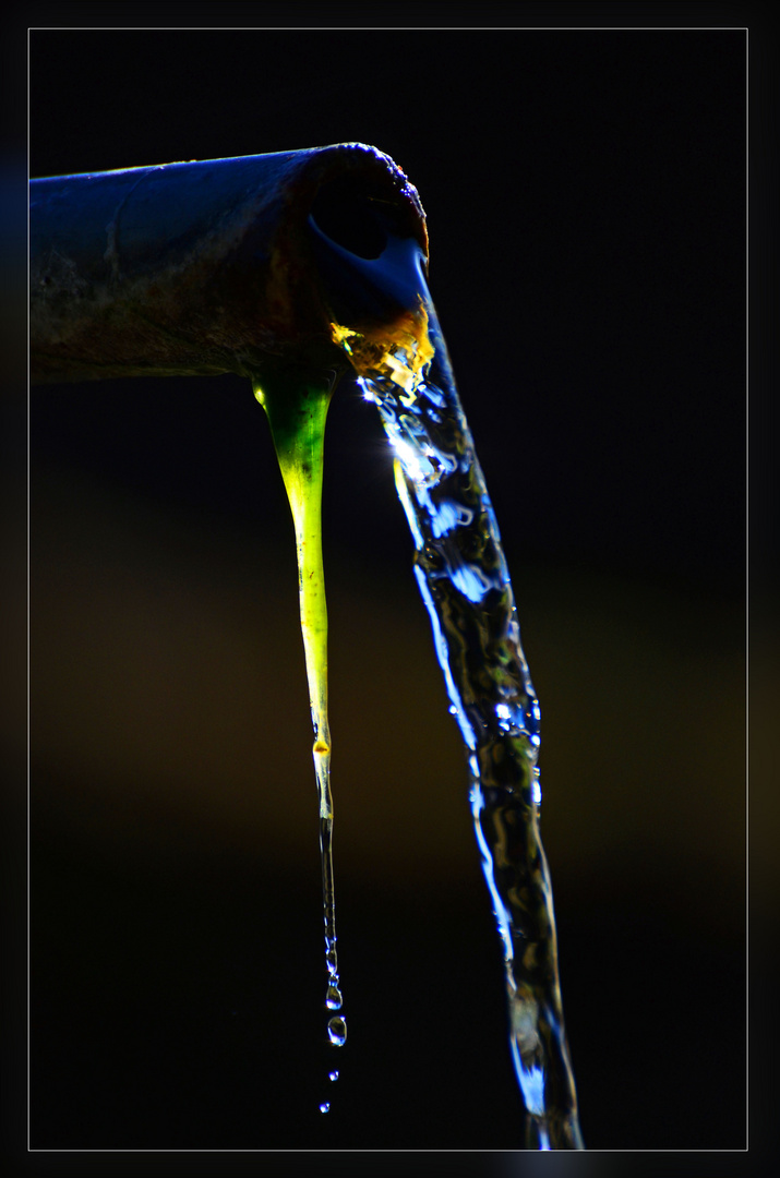 Wasserrohr von einem alten Brunnen im Gegenlicht