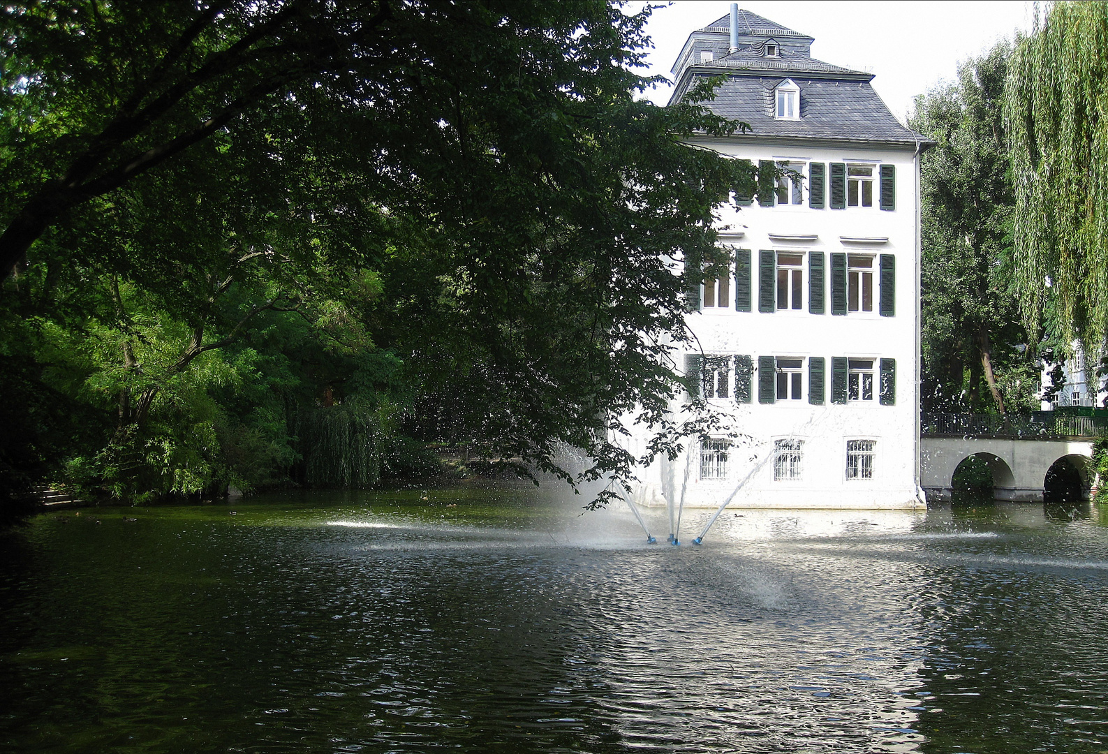 Wasserschloss Holzhausen mit Springbrunnen im See