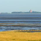 Wattenlandschaft zwischen Festland und Insel von der Morgensonne beleuchtet