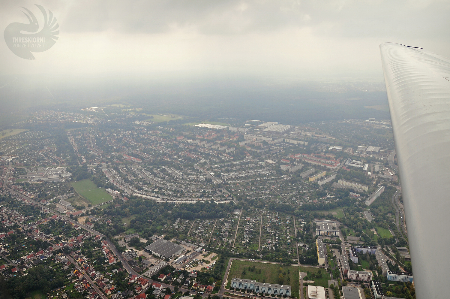 Weiße Flügel und graue Wolken