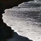 Weißer Wellenschaum auf schwarzem Vulkan-Sandstrand bei Ajuy (Fuerteventura)