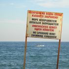 Weißes Schild mit roter Schrift am Schwarzen Meer