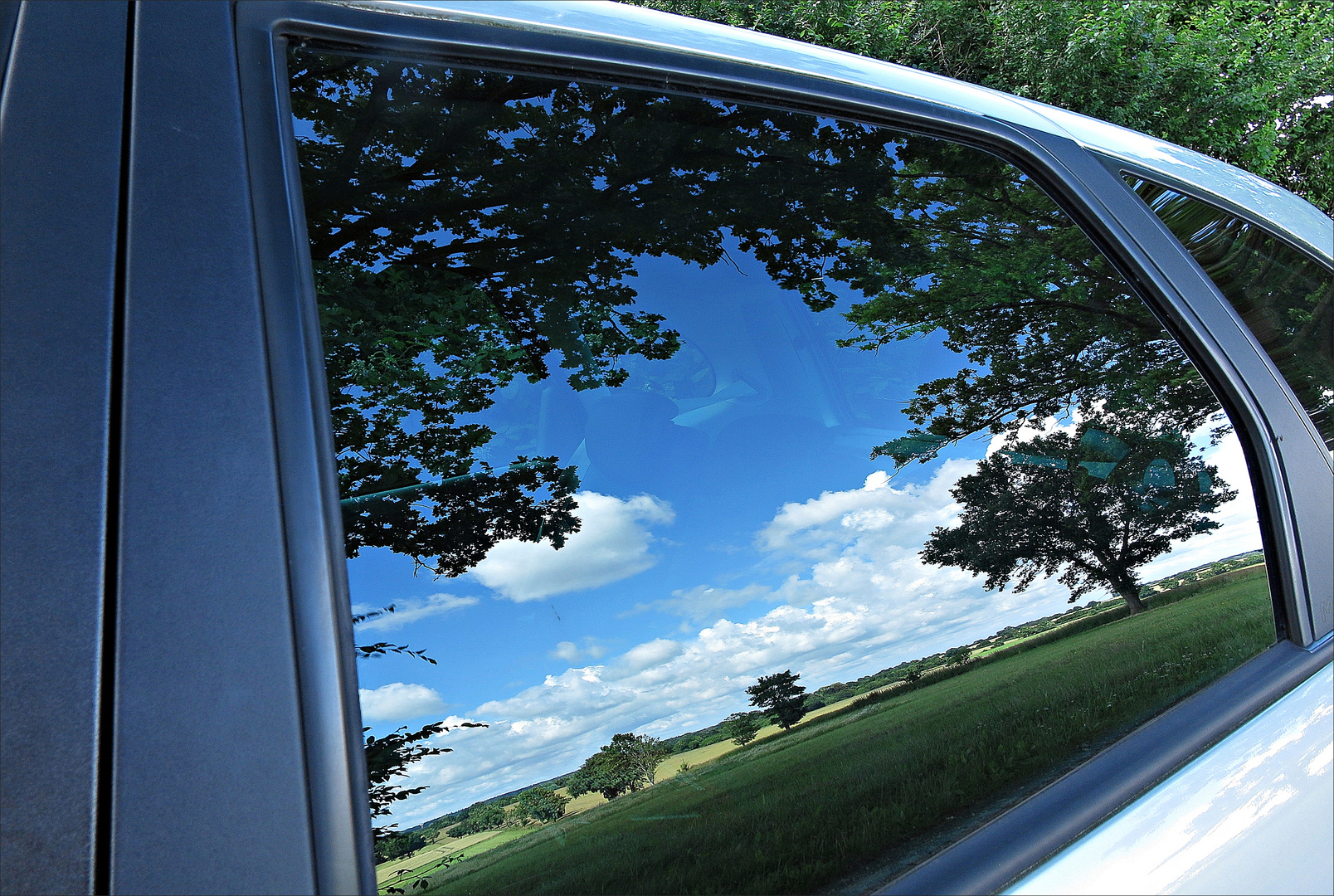 Weiter Blick auf die Felder in Schleswig-Holstein durch die Auto-Fensterscheibe