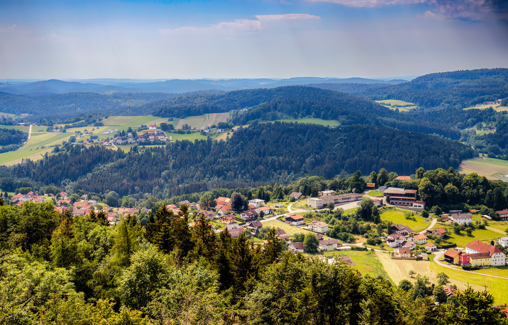 Weites Land in dem sich Wald und Wiesen abwechseln