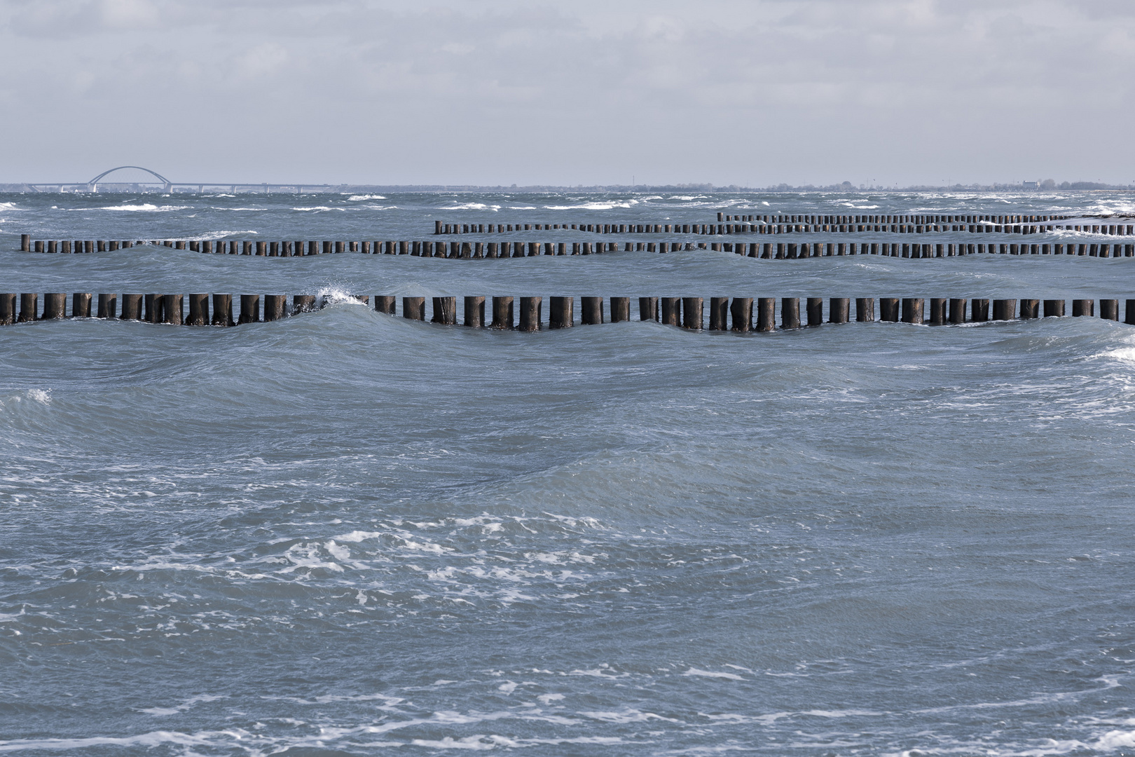 Welle im Meer und Buhne im Sund