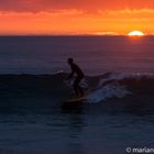 Wellenreiter bei Sonnenuntergang