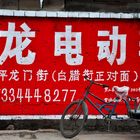 Werbung für Elektroscooter mit Fahrrad in Luoping Yunnan