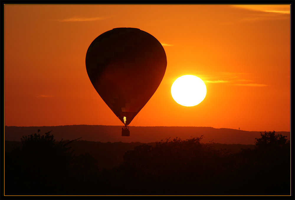 Wie ein glühender Ballon geht die Sonne unter