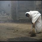 Wife von Bahadur cleaning the road vor ihr haus, easily to recognize an sein umhang