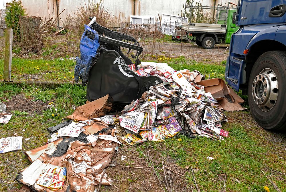 Wilde Müllverbrennung - verkokelter Altpapiercontainer in einem heruntergekommenen Hinterhof