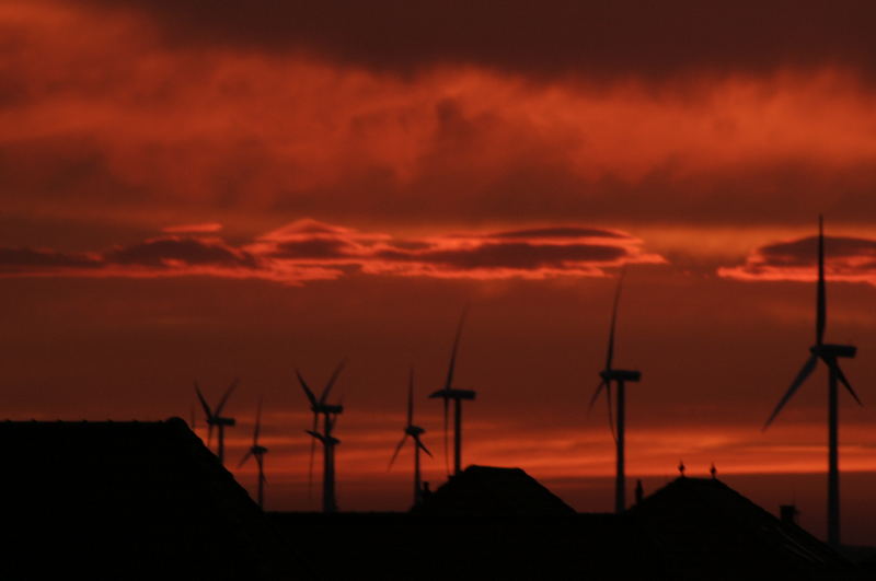 Windmills projecting against a bloodred sky