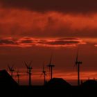 Windmills projecting against a bloodred sky