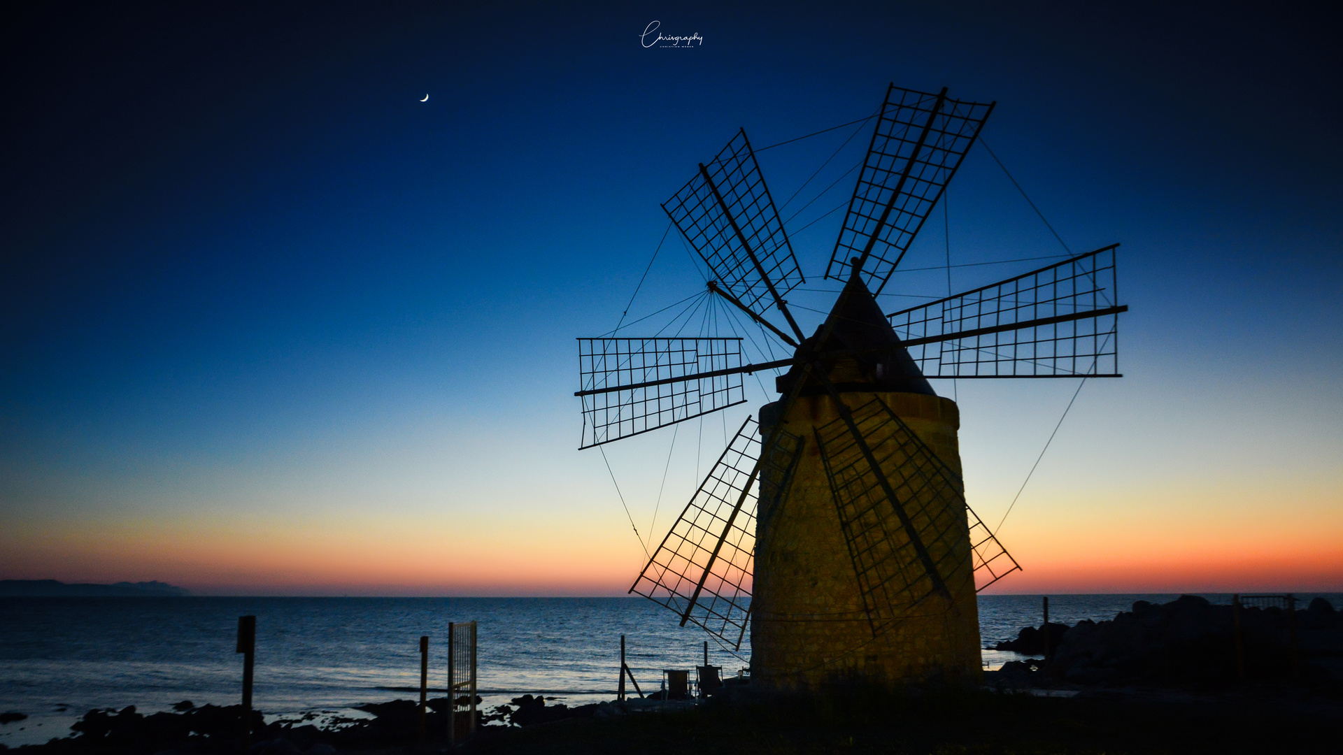 Windmühle am Meer bei Sonnenuntergang