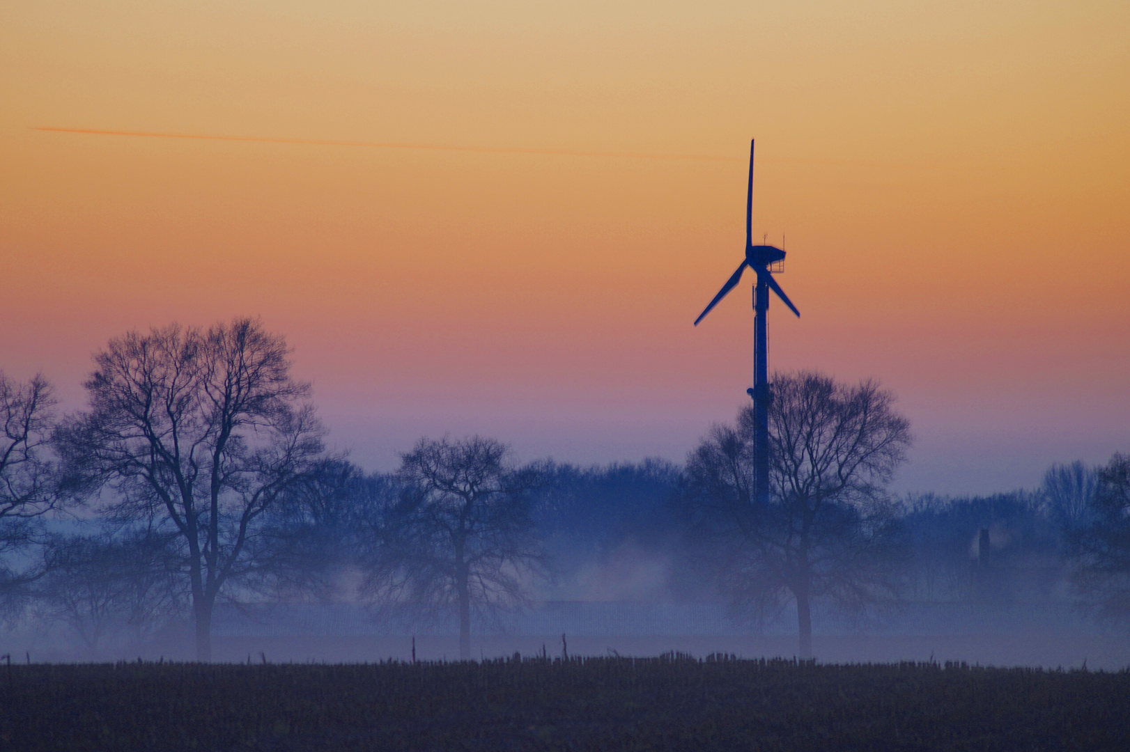 Windrad vor der untergehenden Sonne