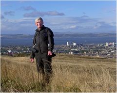 Windzersaust auf Arthurs Seat mit Edinburgh im Rücken