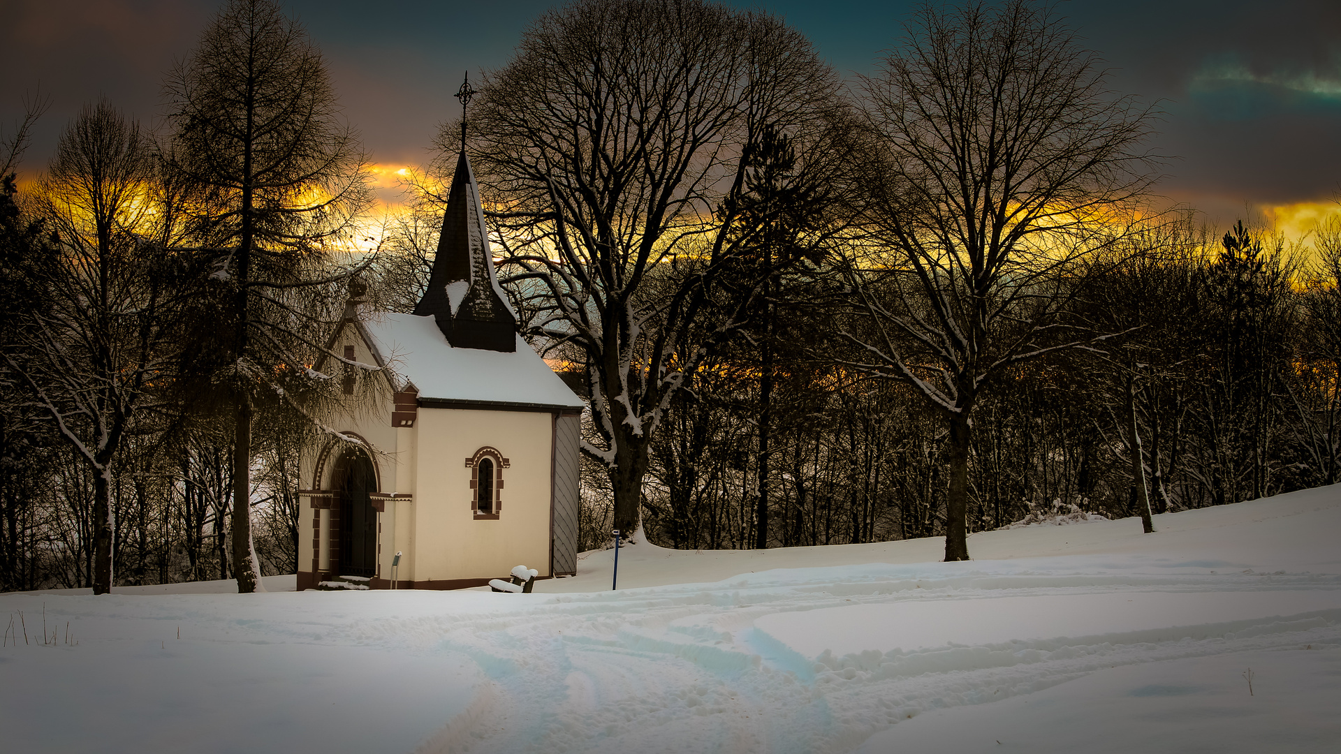 Winterhimmel über verschneiter Kapelle