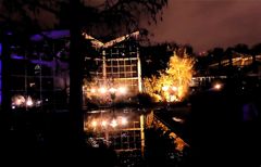 Winterlichter Glashaus mit Lampen in Teich gespiegelt 