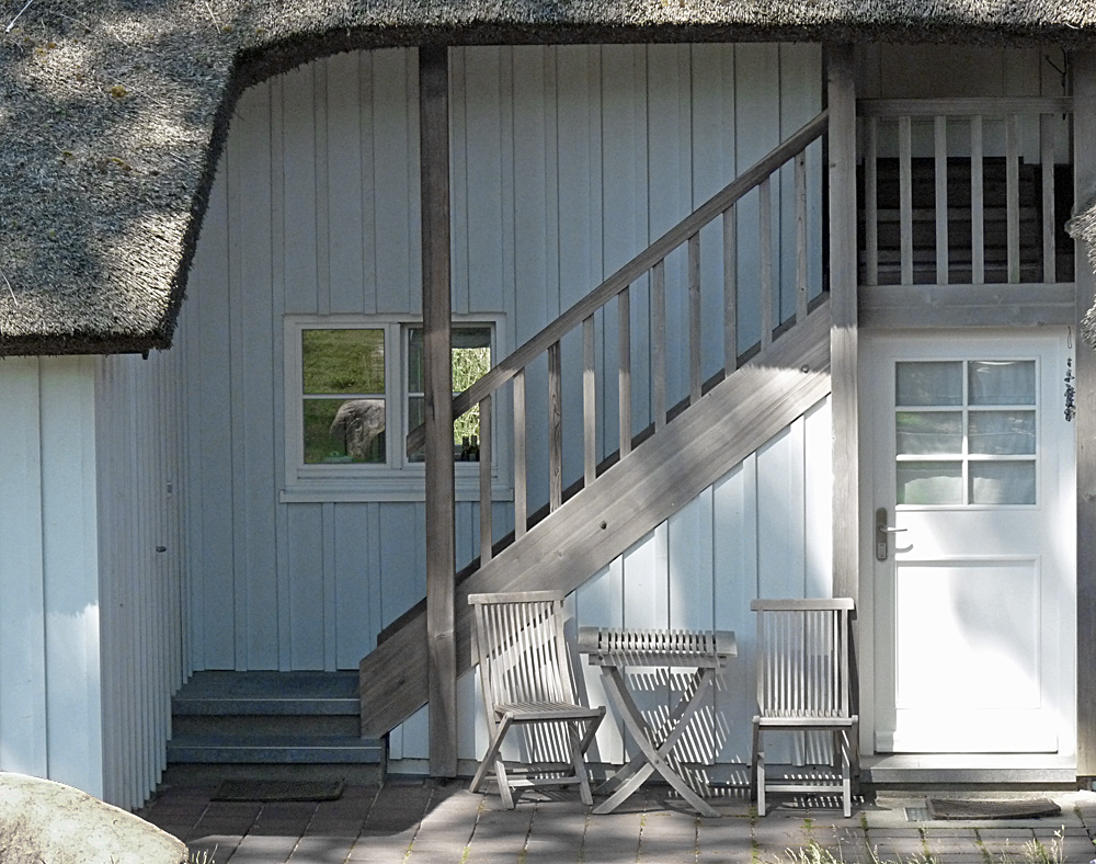 Wohnen am Meer, ein einladender Sitzplatz vor dem Haus unter Reet, Spiel von Sonne und Schatten ...