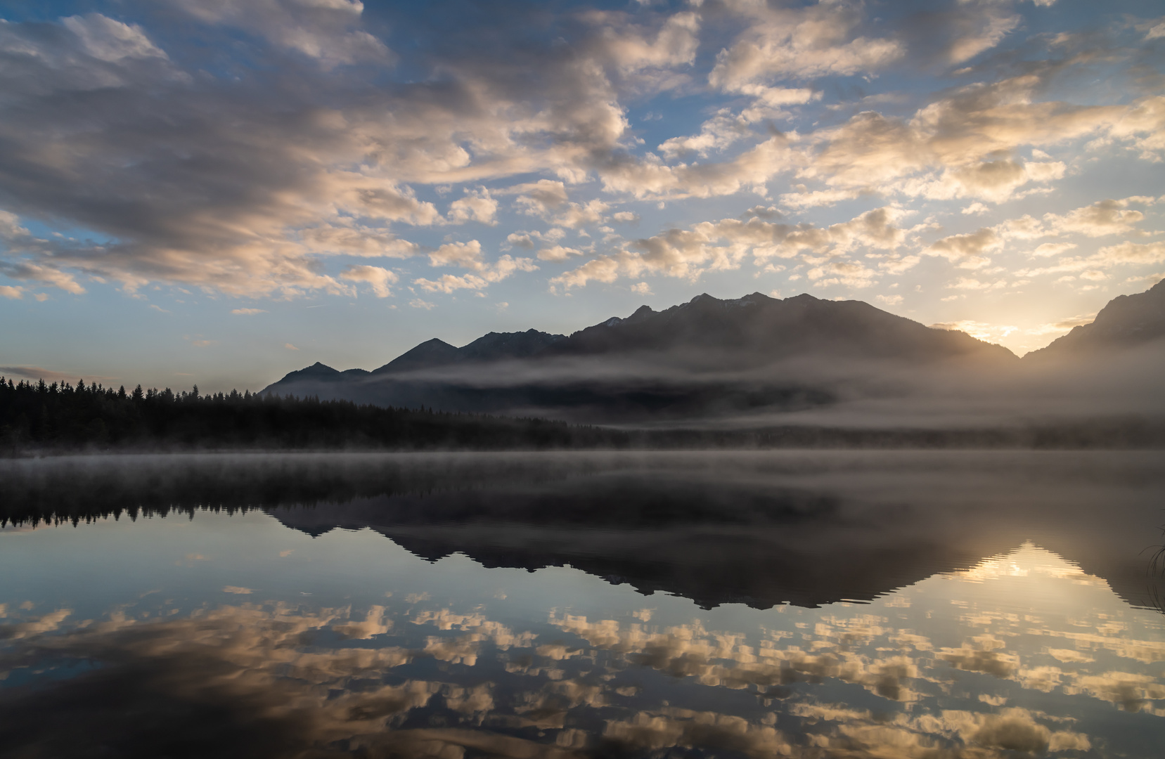 Wolken spiegeln sich im See