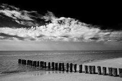 Wolken und Buhnen bei Ebbe