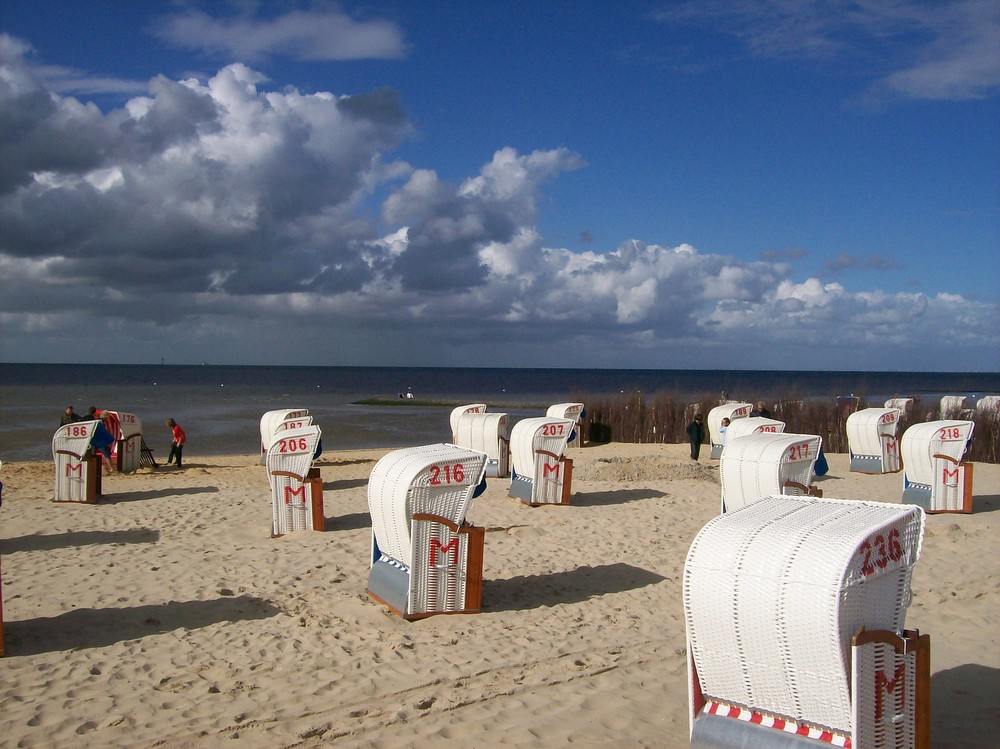 Wolken und weiße Strandkörbe