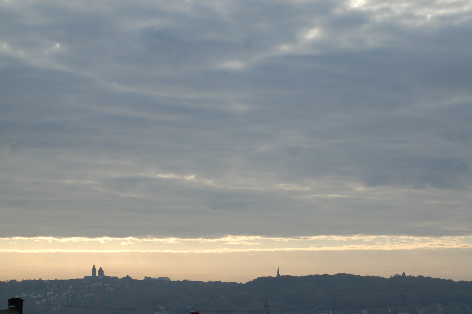 Wolkendecke öffnet sich über der fernen Stadt