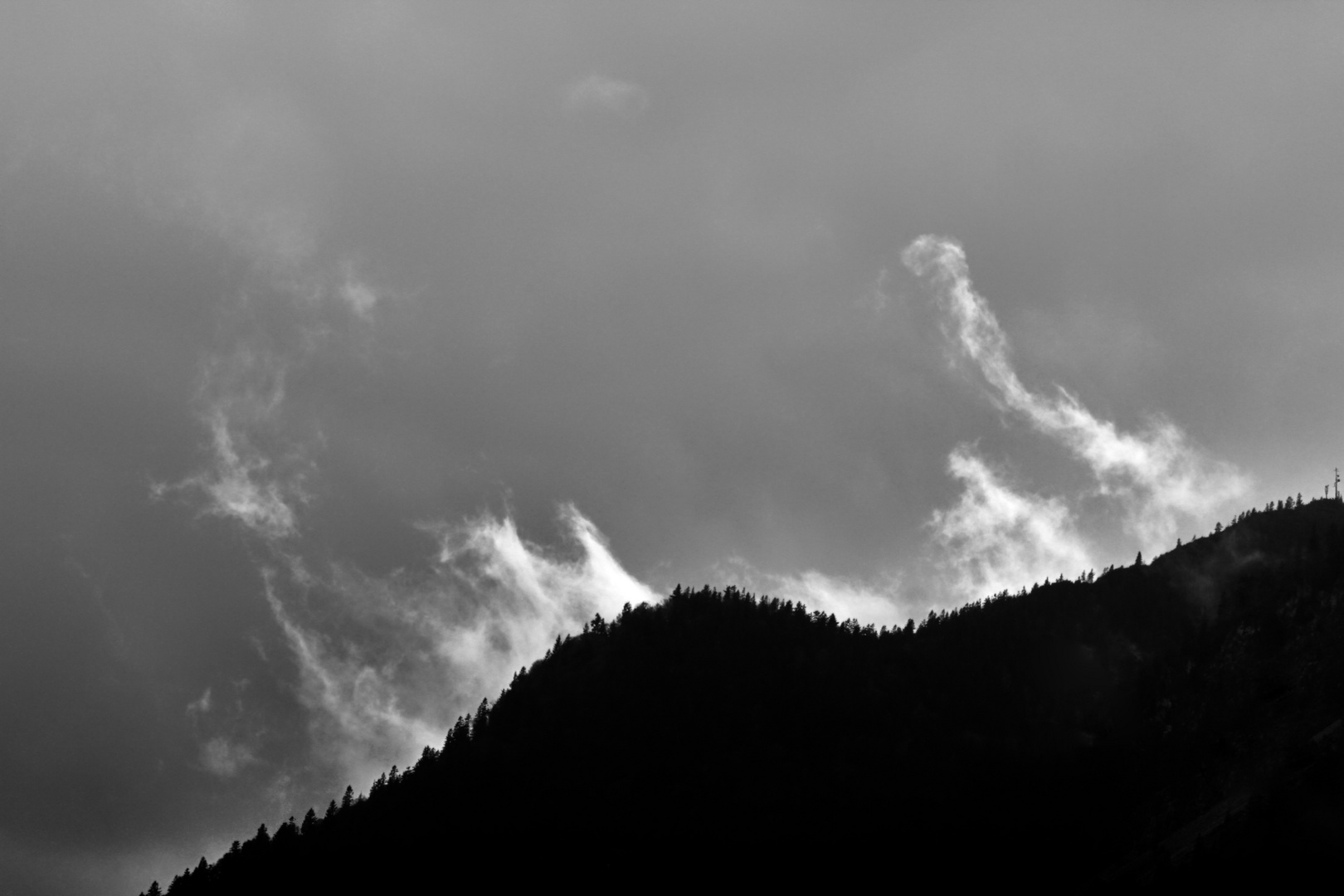 Wolkenfetzen am Hang im Sonnen-Gegenlicht