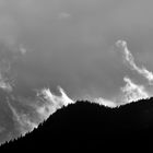 Wolkenfetzen am Hang im Sonnen-Gegenlicht