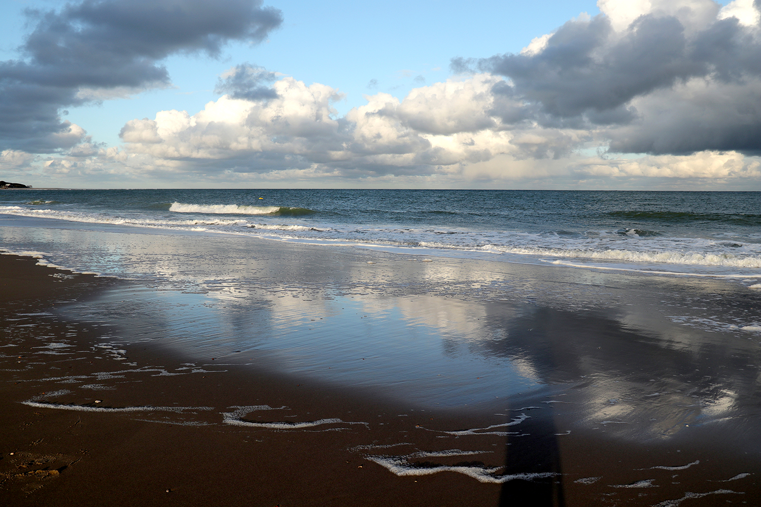 Wolkenspiegelung am Strand