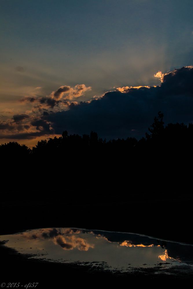 Wolkenstimmung mit Sonnenstrahlen und Spiegelung