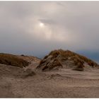 Wolkenverhangene Sonne über den Dünen