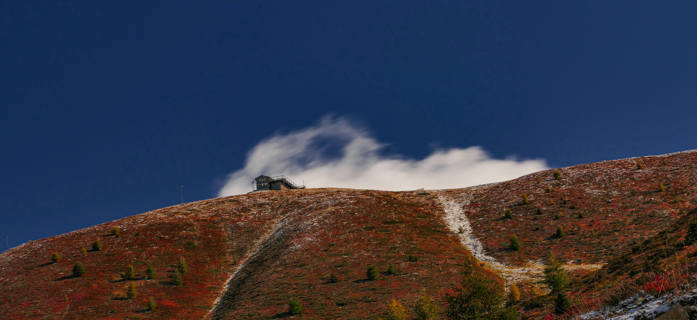 wolkenzug hinter hütte 