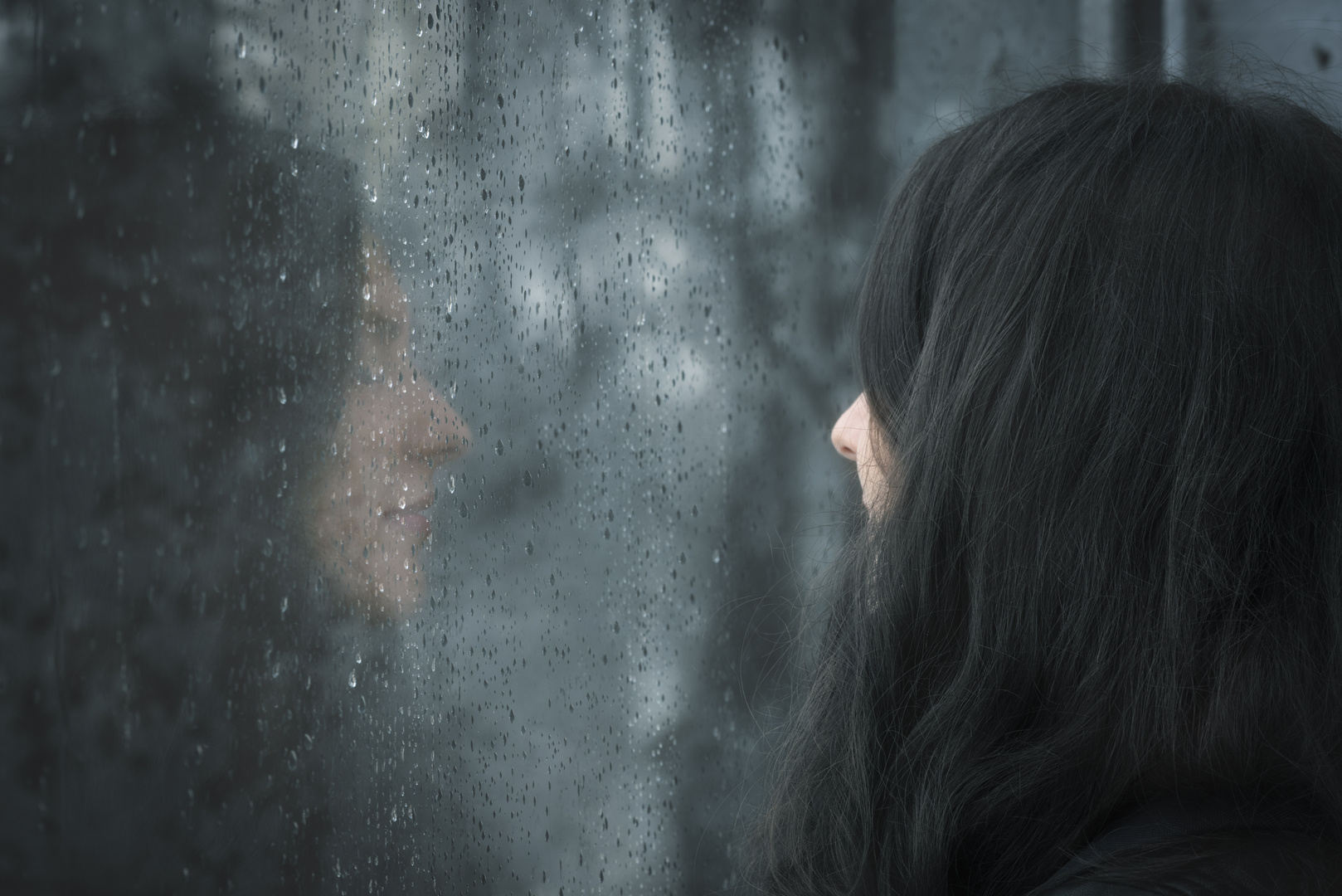 Woman in front of rainy window