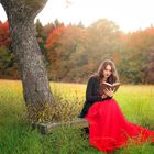 Woman in red dress reading outside