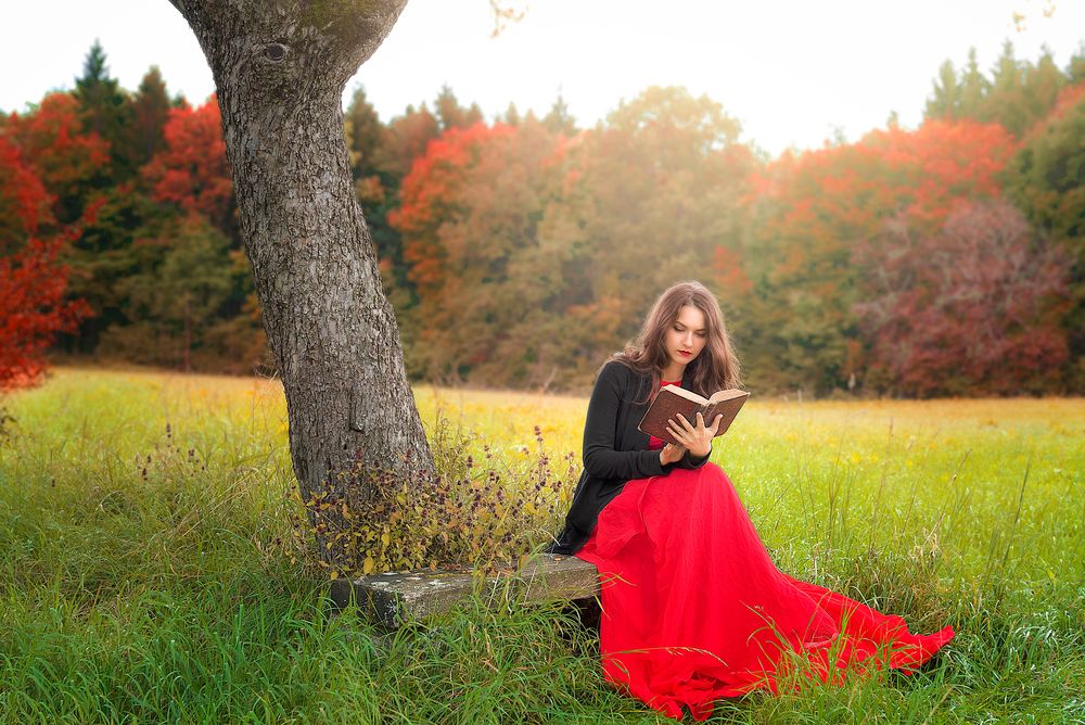 Woman in red dress reading outside