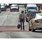 Woman with a very large handbag walks across the street