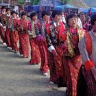 Women in traditional kira enter the tsechu