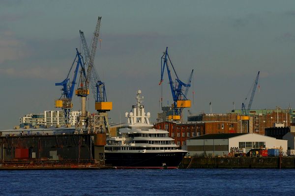 Yacht zwischen zwei Kränen