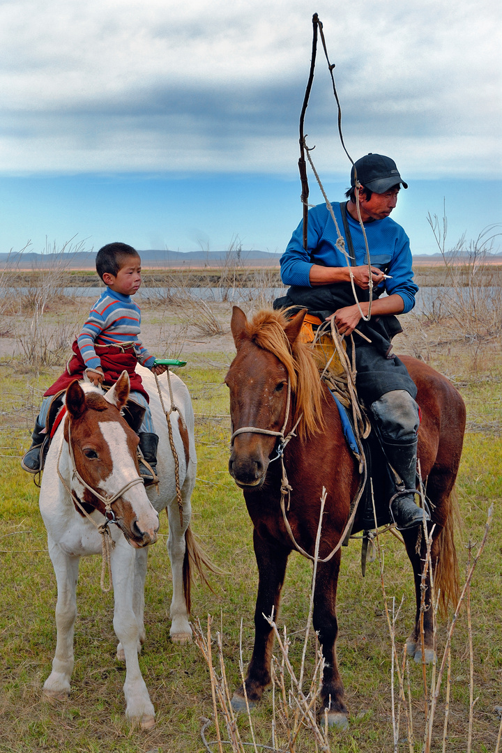 Young boy learns riding the horse