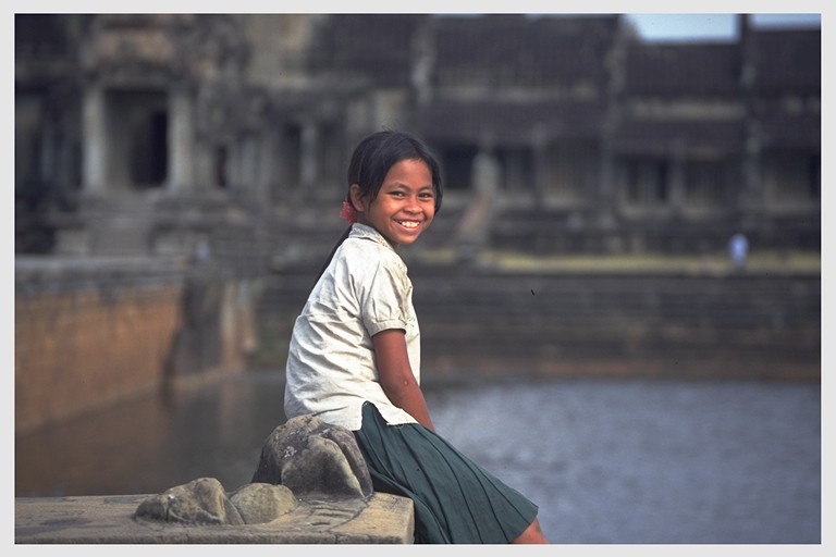 Young girl sitting in front of Angkor Wat