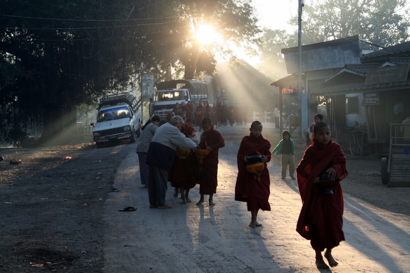 Young monks receiving food donations in the early morning