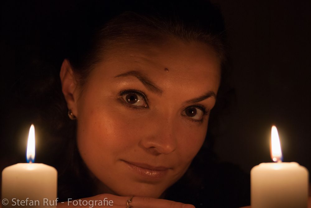 Yulia zwischen zwei Kerzen