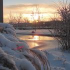 Zugefrorener Wassergraben in Morgensonne