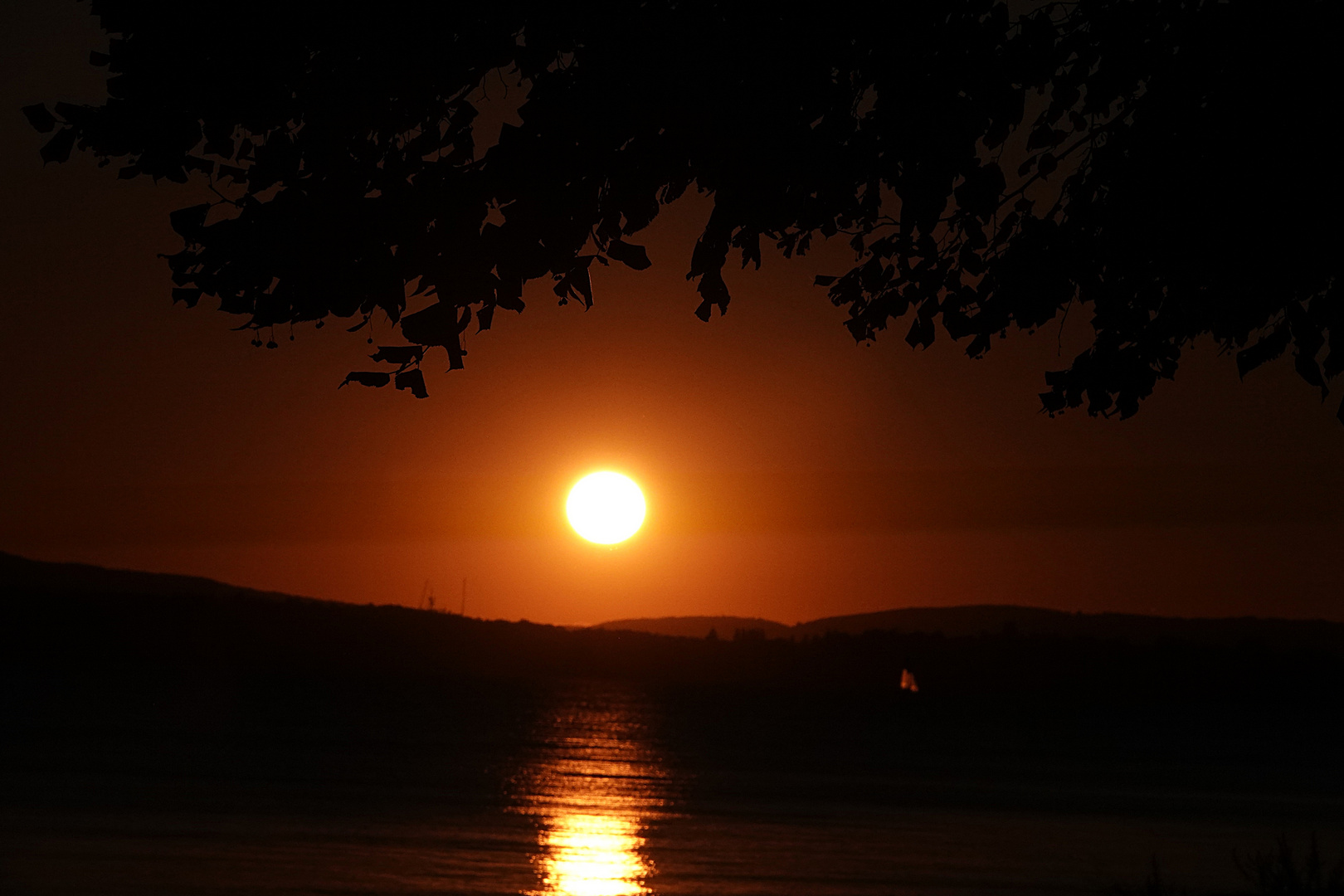 zum Abschied spiegelt sich die Sonne im See