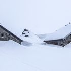 Zwei Alphütten im Schnee