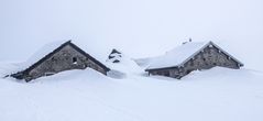 Zwei Alphütten im Schnee