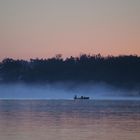 zwei Fischer bei der Arbeit am frühen Morgen am Chiemsee