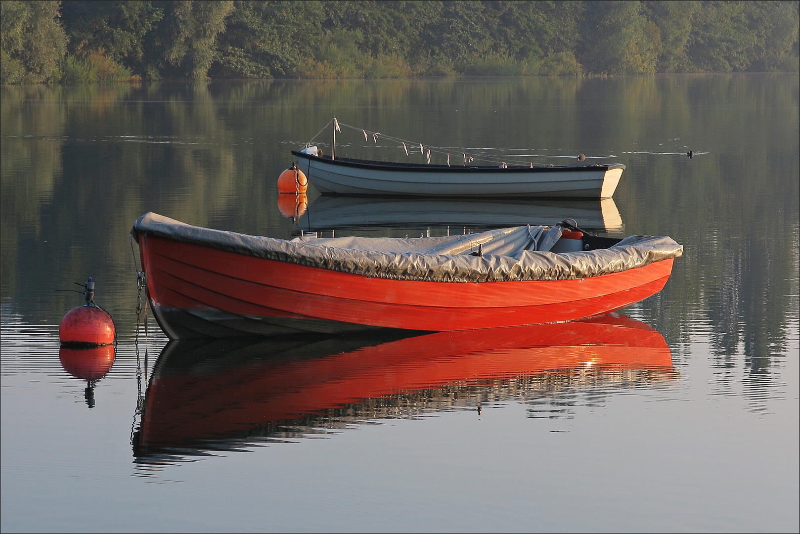 Zwei Fischerboote spiegeln sich im Schöhsee