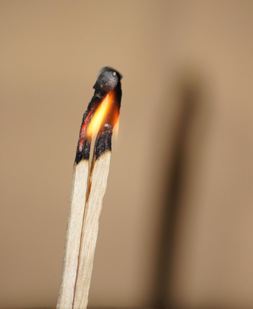 zwei Hölzer, eine Flamme