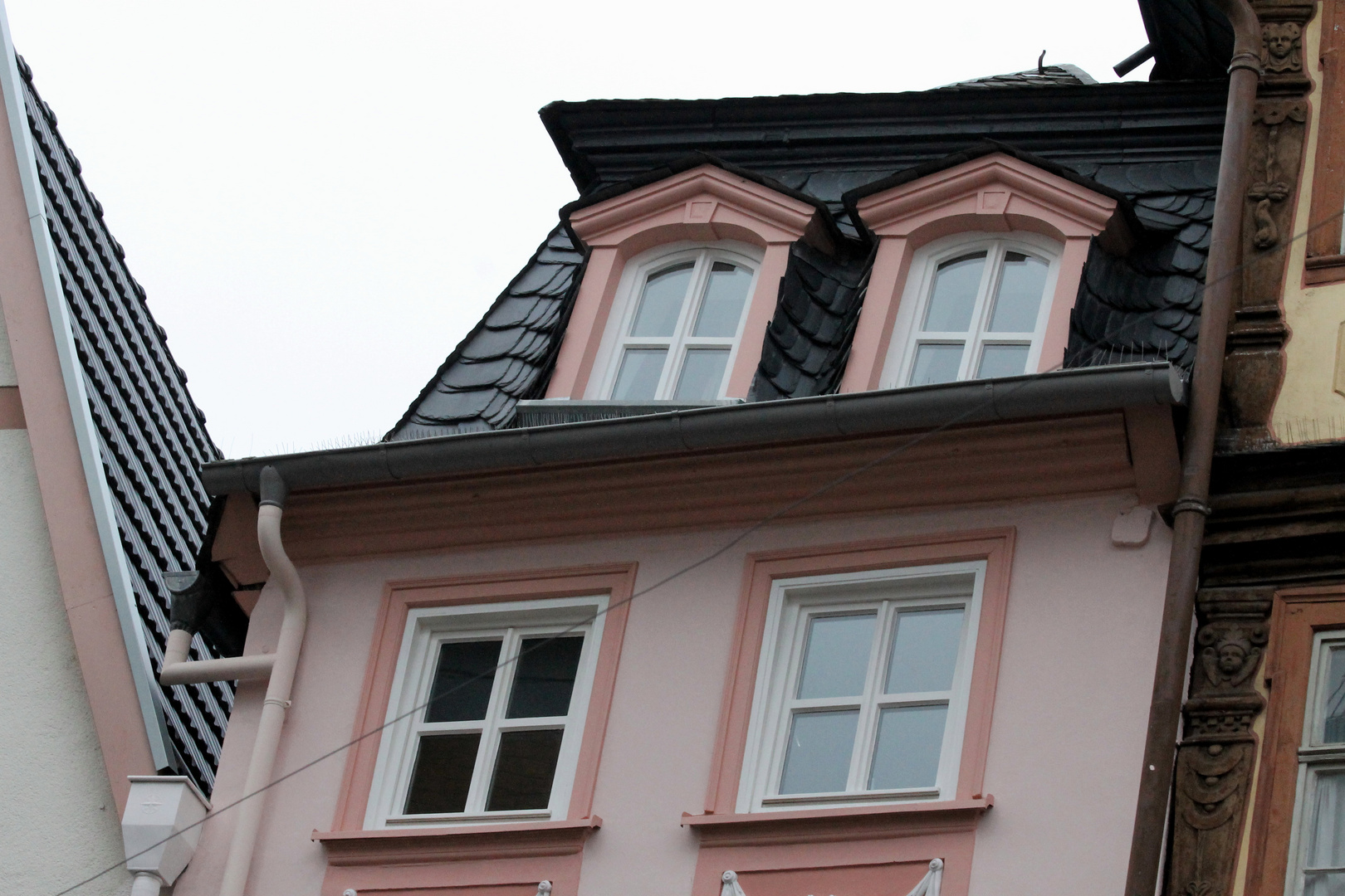 Zwei krumme Fenster in einem alten Haus